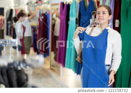 Young girl choosing party dress in clothing store 122158732