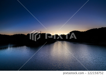 A warm evening at Nunome Dam in the middle of winter. A cloudless sky and a beautiful lake surface. The darkening sky and the sunset that remains in a semicircle. 122158752
