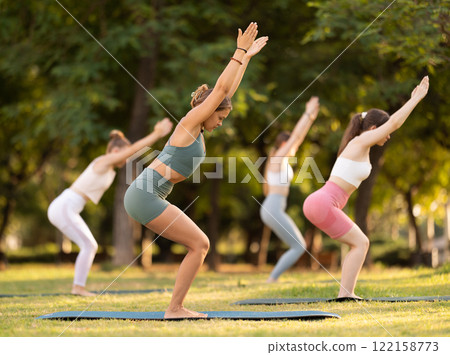 Group of young women doing yoga in park Group of young women doing yoga in park 122158773