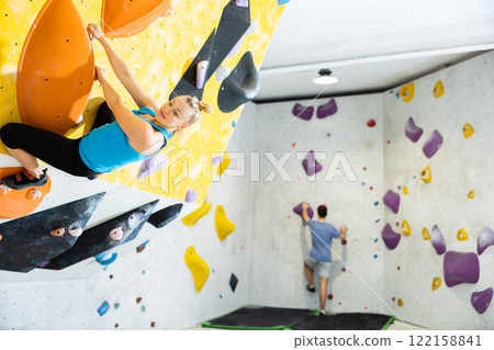 Woman exercising in climbing gym 122158841