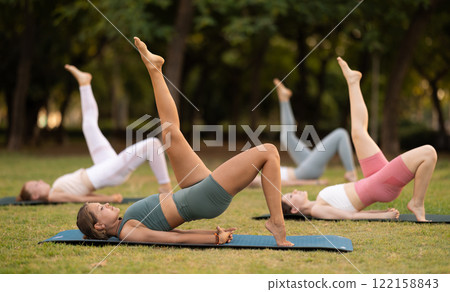 Group of young women doing yoga in park 122158843