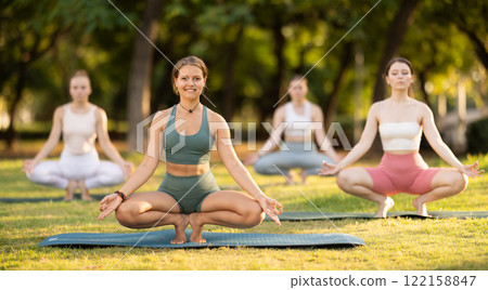 Yoga lesson visitors girls perform prapadasana in park Yoga lesson visitors girls perform prapadasana in park 122158847