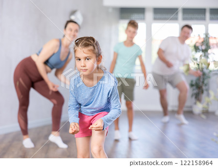 Positive pre teenage dancers and his parent doing dance workout during group class 122158964