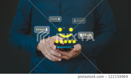 Person using a smartphone, giving a five-star rating and a happy face icon. Business service customer experience concept of customer feedback, reviews, and satisfaction in a digital setting. Person using a smartphone, giving a five-star rating and a happy face icon. Business service customer experience concept of customer feedback, reviews, and satisfaction in a digital setting. 122158969
