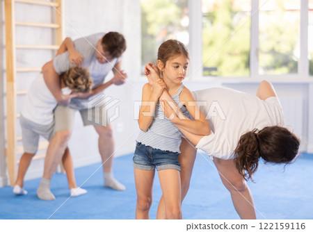 Mother and daughter training self-defense techniques 122159116