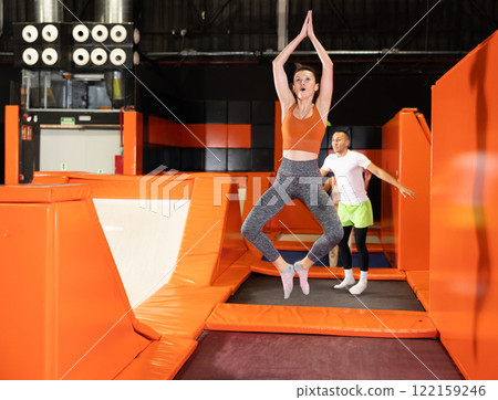 Middle-aged woman practice jumping on trampolines at trampoline center 122159246