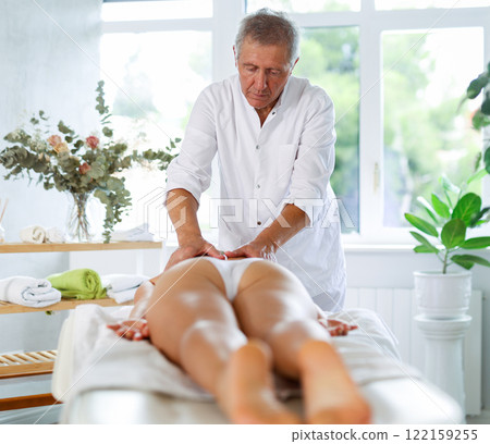 male masseur giving massage to female patient male masseur giving massage to female patient 122159255