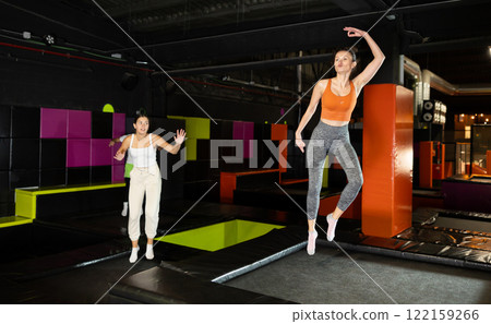 Excited woman enjoying jumping at well-equipped indoor trampoline arena 122159266
