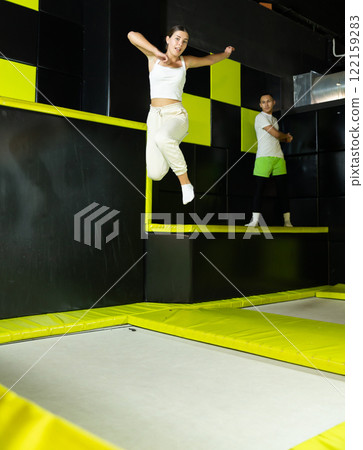 Excited young girl jumping at indoor trampoline center Excited young girl jumping at indoor trampoline center 122159283