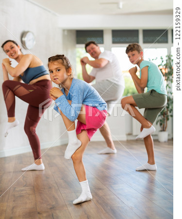 At home child learns to perform boogie-woogie figures with family 122159329