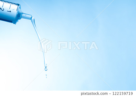 水滴從注射器形狀的滴管中落下 水滴從注射器形狀的滴管中落下 122159719