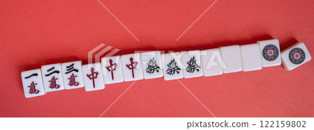 Mahjong tiles on a red background Mahjong tiles on a red background 122159802
