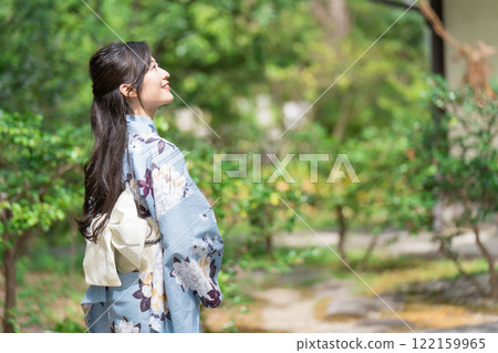 A young woman wearing a yukata in the midst of fresh greenery, upper body A young woman wearing a yukata in the midst of fresh greenery, upper body 122159965