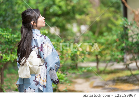 A young woman wearing a yukata in the midst of fresh greenery, upper body 122159967
