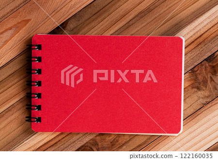 Red notepad on a wood background Red notepad on a wood background 122160035