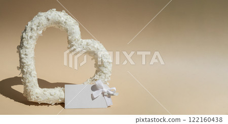 Empty paper note mock up White lilac flowers heart shaped in pastel backdrop. Symbol of love floral arrangement. Spring concept idea Valentine's Day, weeding proposal postcard copy space Empty paper note mock up White lilac flowers heart shaped in pastel backdrop. Symbol of love floral arrangement. Spring concept idea Valentine's Day, weeding proposal postcard copy space 122160438