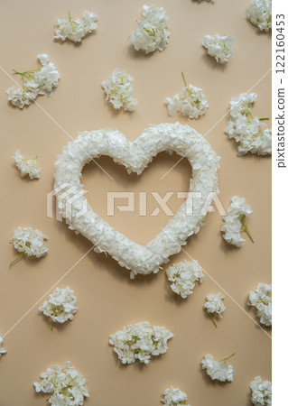 Heart made of white lilac flowers on pastel beige background. Still life romantic composition of Valentines day holiday copy space for your text invitation greeting card Heart made of white lilac flowers on pastel beige background. Still life romantic composition of Valentines day holiday copy space for your text invitation greeting card 122160453