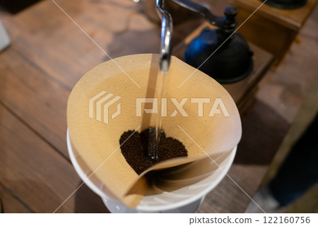 Pouring hot water onto freshly ground coffee beans. 122160756