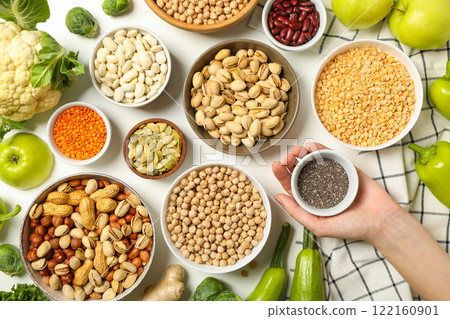 Set of vegan protein products in bowls and hand on white background, top view 122160901