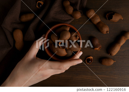Ripe tamarind in a bowl on a wooden background 122160916