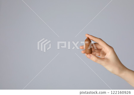 Ripe tamarind in female hands on a light background 122160926