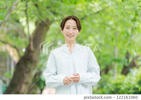 A woman in her 30s standing in the fresh greenery A woman in her 30s standing in the fresh greenery 122161060