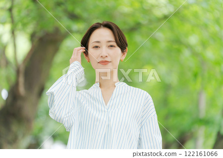 A woman in her 30s standing in the fresh greenery 122161066
