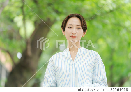 A woman in her 30s standing in the fresh greenery A woman in her 30s standing in the fresh greenery 122161068