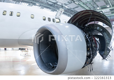 Close-up of an open high bypass turbofan airplane engine of a passenger aircraft in a hangar Close-up of an open high bypass turbofan airplane engine of a passenger aircraft in a hangar 122161313