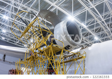 Open high-bypass turbofan aircraft engine of a transport airplane in a hangar 122161333