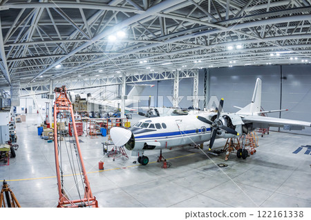 Transport aircrafts in the hangar. Airplanes under maintenance. Checking mechanical systems for flight operations Transport aircrafts in the hangar. Airplanes under maintenance. Checking mechanical systems for flight operations 122161338