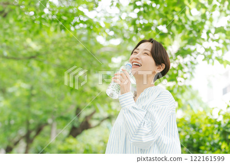 Woman hydrating in the park Woman hydrating in the park 122161599