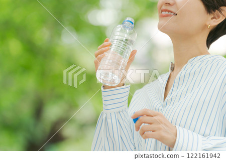 一位女士在新鮮的綠色植物中補充水分 122161942