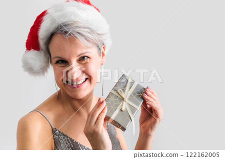 Beautiful smiling mature middle aged woman smiling and holding gift box. 122162005