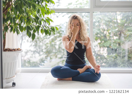 Yoga woman sitting in lotus position with hand mudra gyan jnana practice at home 122162134