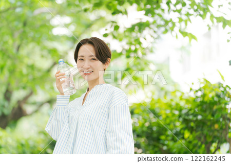 公園裡拿著塑膠瓶的女人 122162245