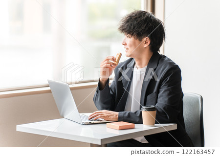Businessman/man working on a computer in a cafe Businessman/man working on a computer in a cafe 122163457