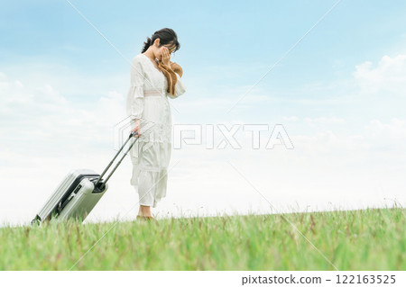 A woman traveling with a suitcase (heartbreak trip/retreat) 122163525
