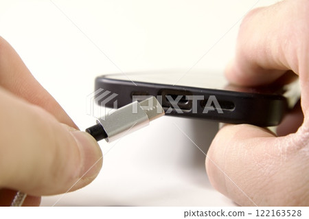 USB Type C cable and smartphone in hand 122163528