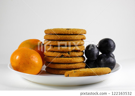 crispy cookies and fruits on a plate on a white background crispy cookies and fruits on a plate on a white background 122163532