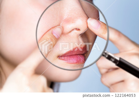 用放大鏡放大女人的鼻子。 122164053