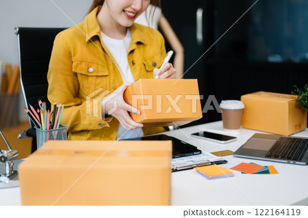 Startup small business SME, Entrepreneur owner woman using smartphone or tablet taking receive and checking online purchase shopping order 122164119
