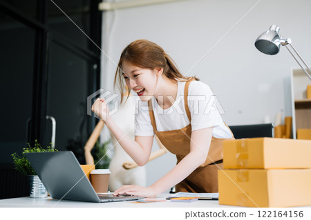 Startup small business SME, Entrepreneur owner woman using smartphone or tablet taking receive and checking online purchase shopping order Startup small business SME, Entrepreneur owner woman using smartphone or tablet taking receive and checking online purchase shopping order 122164156