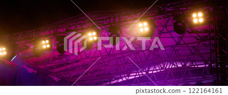 Close-up view of professional stage lighting mounted on metal truss. Bright spotlights at concert stage. Live music event Close-up view of professional stage lighting mounted on metal truss. Bright spotlights at concert stage. Live music event 122164161
