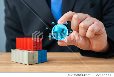 Businessman holding globe of planet Earth over stack of shipping containers. World trade and economic processes. Globalization. Import, export, transportation of goods and logistics. Production chains 122164555