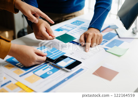 Close up view of UI developer team brainstorming on their project with laptop, smartphone and digital tablet. Creative digital development agency. 122164559