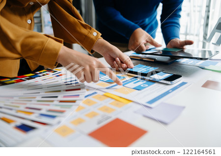 Close up view of UI developer team brainstorming on their project with laptop, smartphone and digital tablet. Creative digital development agency. Close up view of UI developer team brainstorming on their project with laptop, smartphone and digital tablet. Creative digital development agency. 122164561