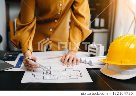business woman hand working and laptop with on on architectural project at construction site at desk in modern office business woman hand working and laptop with on on architectural project at construction site at desk in modern office 122164730