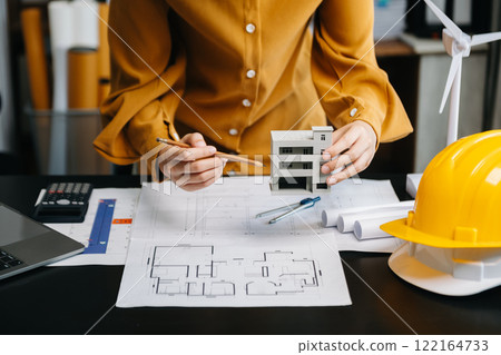 Close up of business people having consultation about wind energy at company office. on architectural project site and making model house. Asian industry professional Close up of business people having consultation about wind energy at company office. on architectural project site and making model house. Asian industry professional 122164733