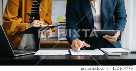 Businessman and team analyzing financial statement Finance task. with smart phone and laptop and  tablet. Wealth management concept in office 122164776
